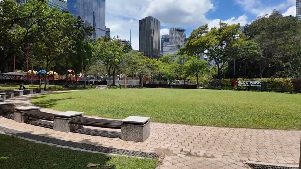 Open lawn in KLCC Park with the KL skyline