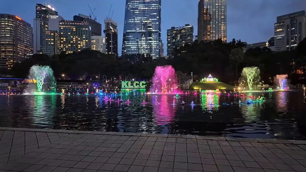 Colorful fountain show on the lake with the KL skyline at dusk