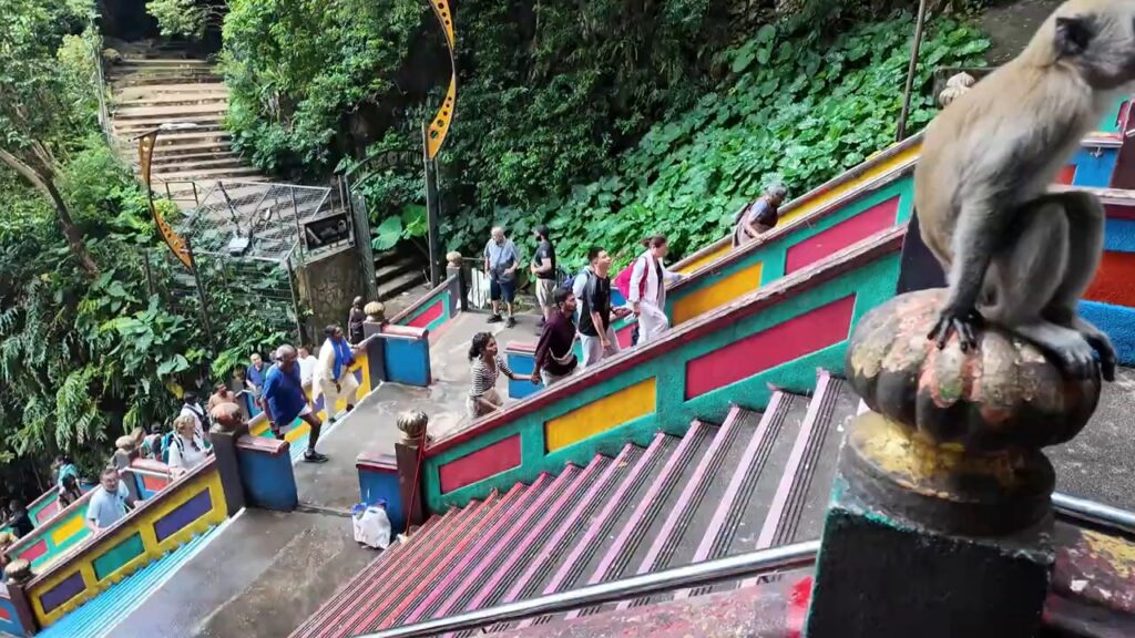 Long-tailed macaque sitting on the railing of the Batu Caves stairs