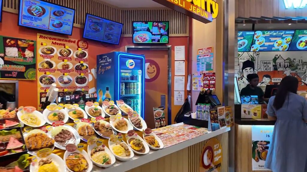 Plates of Malaysian dishes on display at a Signatures Food Court stall
