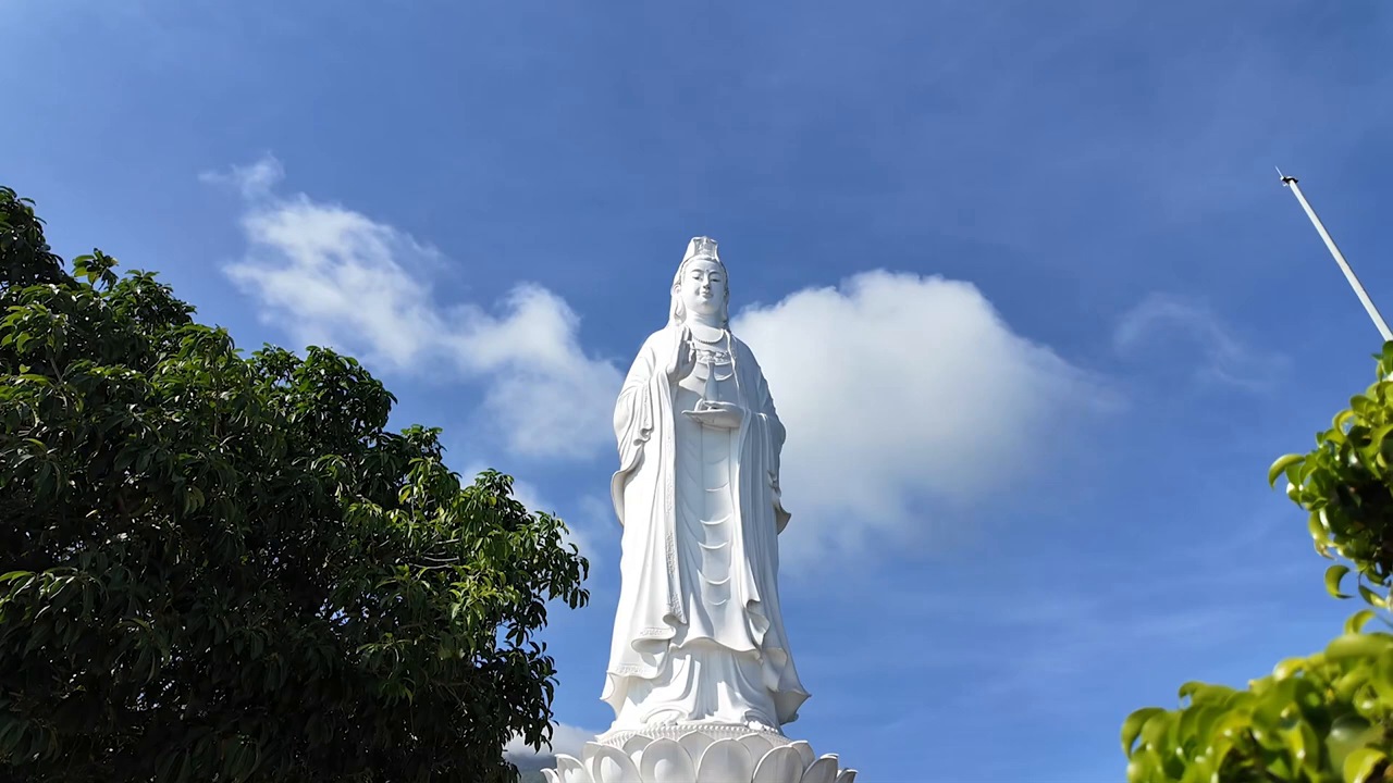 The white Lady Buddha statue against a blue sky at Linh Ung Pagoda, Da Nang