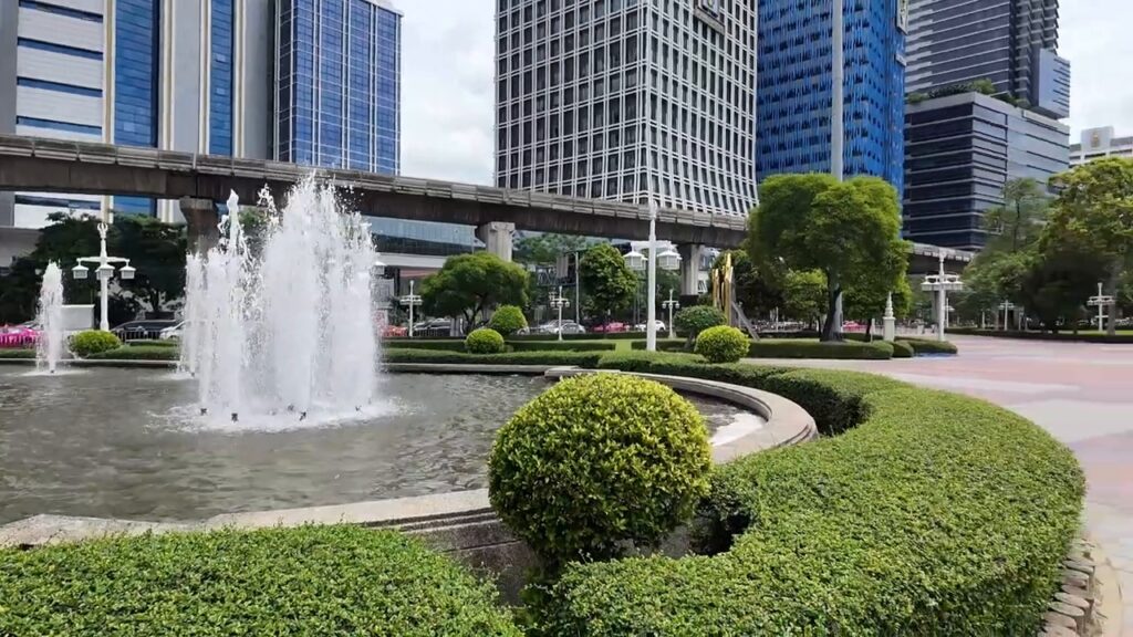 Fountain at the entrance of Lumphini Park with Bangkok towers behind