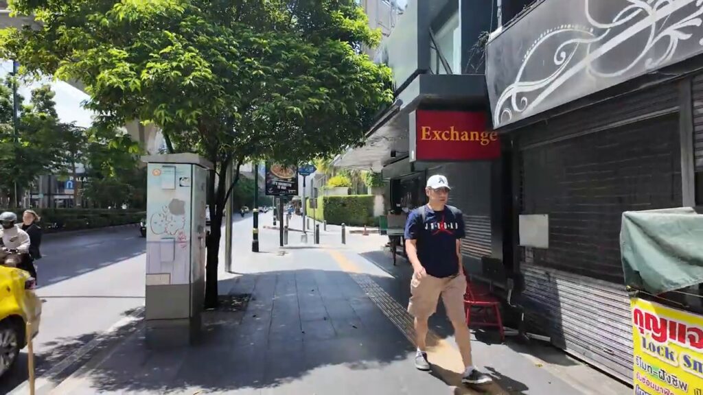 Shops and a pedestrian on Sukhumvit Road between Phrom Phong and Thong Lo