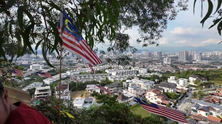 Malaysian flags and a view over Kuala Lumpur neighborhoods from Sri Bintang Hill
