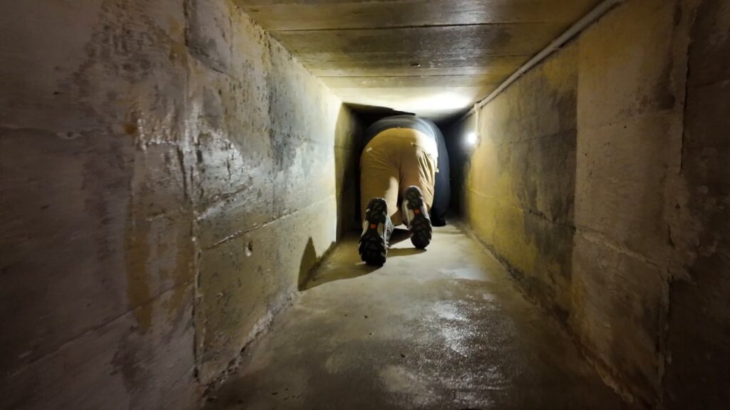 Crawling through a narrow escape tunnel at the Penang War Museum