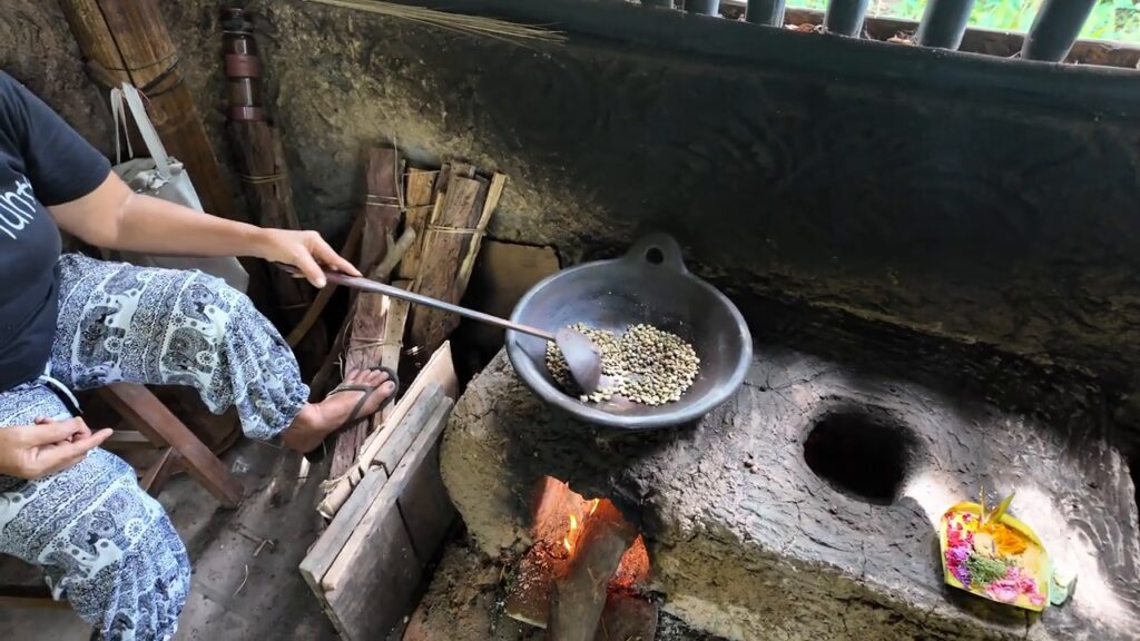 Coffee beans being roasted over a fire at Satria Agrowisata