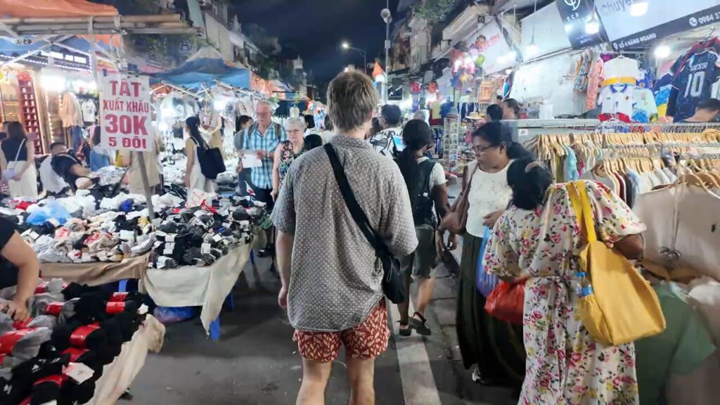 Crowds walking between stalls at the Hanoi weekend night market