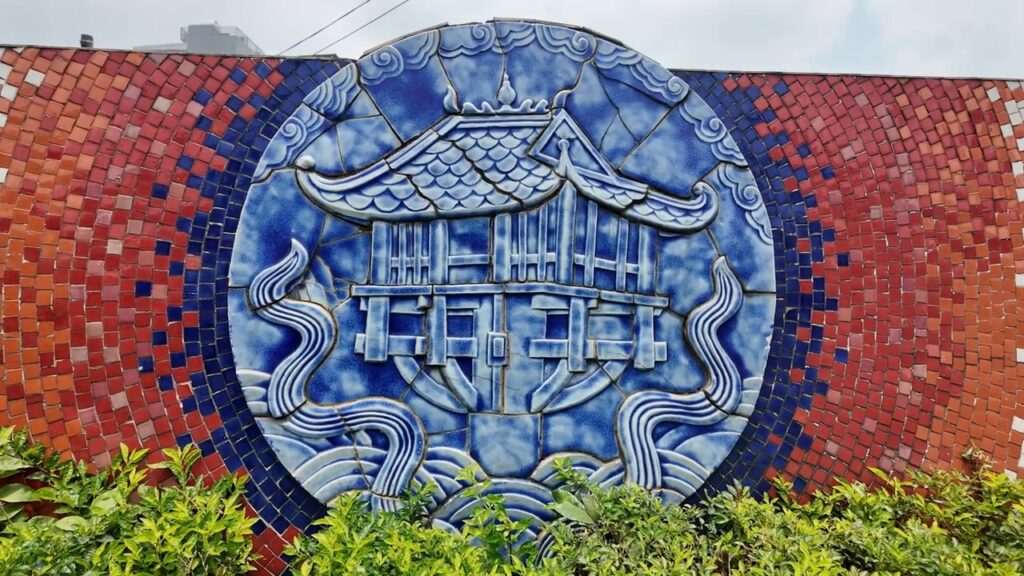 Blue ceramic medallion of a pagoda on the Hanoi mural