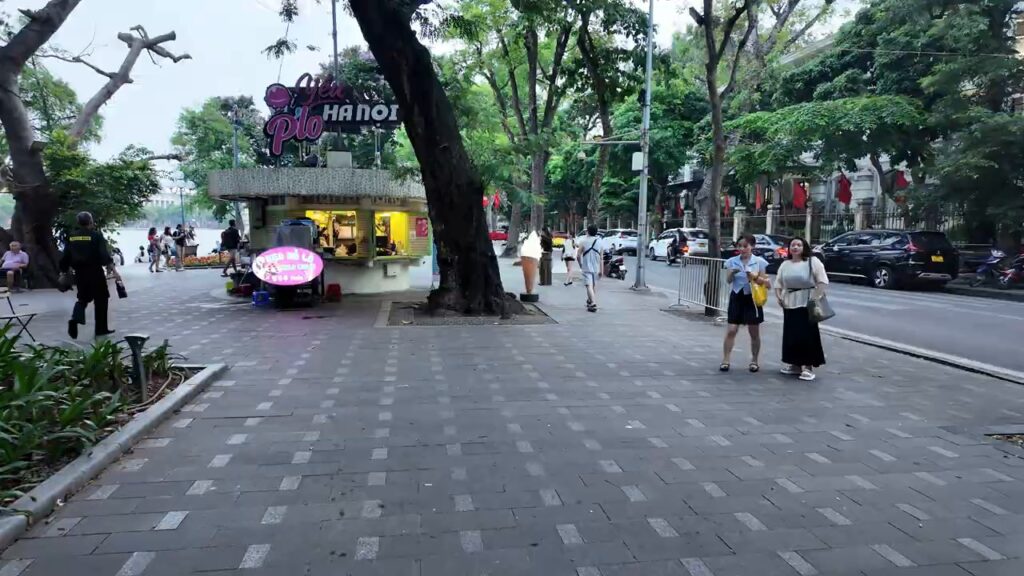 People walking the lakeside promenade around Hoan Kiem Lake