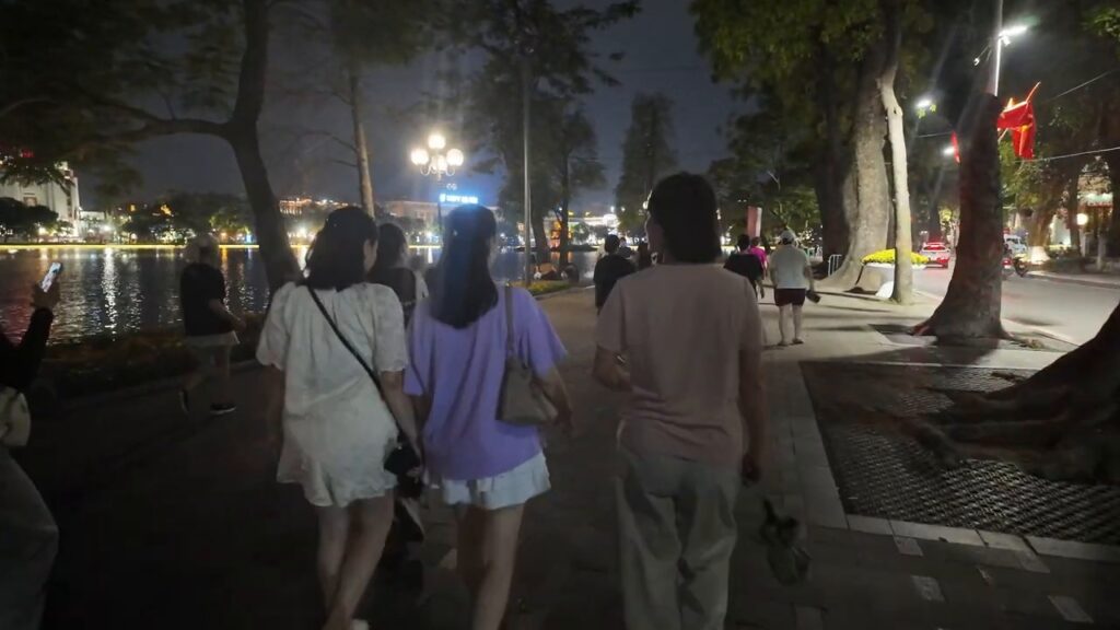 People strolling along Hoan Kiem Lake at night