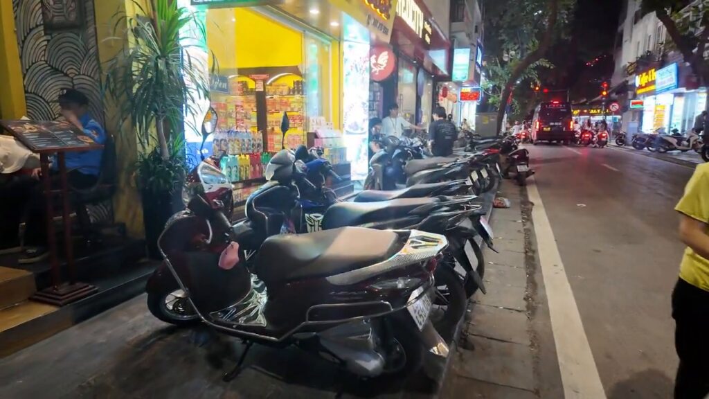 Rows of scooters parked along an Old Quarter street at night