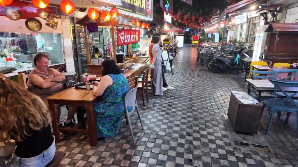 Travelers eating at sidewalk tables in the Hanoi Old Quarter